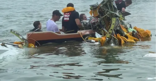 TRAGEDIA DEL ACCIDENTE Un niño pequeño se encuentra entre los cinco muertos después de que un avión de la marina que transportaba pacientes con quemaduras se estrellara en un estuario mientras los rescatistas buscaban a un desaparecido