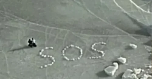 SALVA NUESTRAS ALMAS! Un desesperado mensaje de SOS escrito con trozos de hielo marino salva a dos esquiadores en apuros en una bahía congelada después de que su equipo cayera al agua.